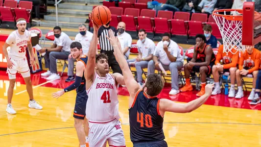Sukhmail Mathon attempts a hook shot with a waving defender in his face.