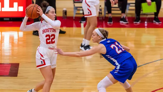 Maggie Pina holds the ball at the top of the arc against an American defender.