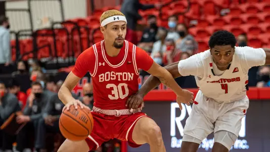 Javante McCoy handles the ball with a Hartford defender on his left trying to stick a hand at the ball.