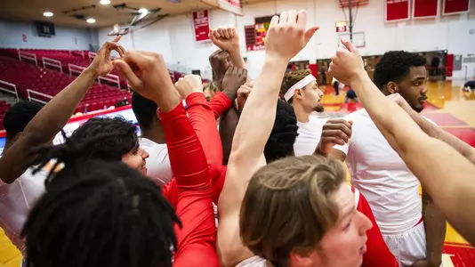 The Boston University men's basketball team huddled together