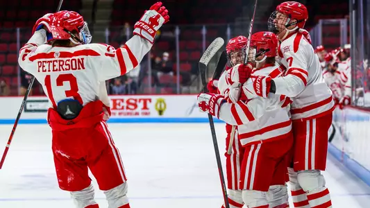 The men's ice hockey team celebrates a goal