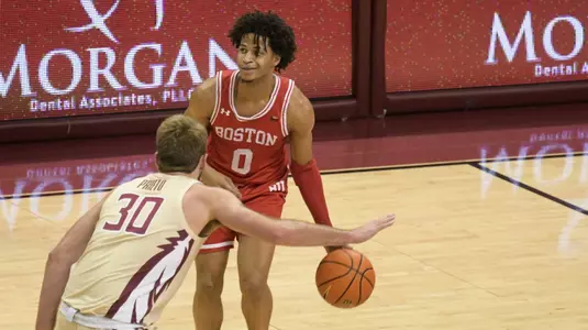 Ethan Brittain-Watts dribbles the ball with a Florida State defender in front with right arm stretched out.