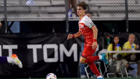 Quinn Matulis brings the ball up the field with an Albany defender running in stride.