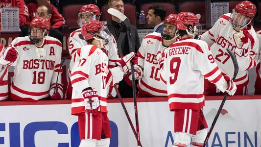 Quinn Hutson and Ryan Greene skate by the BU bench to celebrate a goal