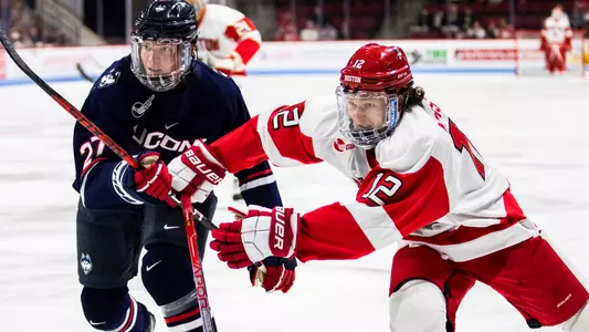 Jamie Armstrong of the BU men's hockey team races a UConn player to a loose puck