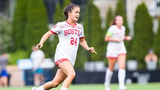 Photo of women's soccer junior Lily Matthews dribbling the ball up the field.