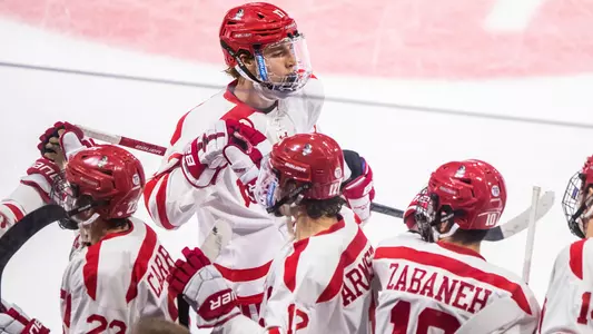 Quinn Hutson skates by the BU bench to celebrate a goal