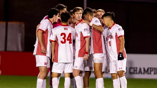 BU men's soccer starts huddle on the field.