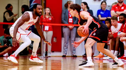 Jonas Harper gets in a defensive crouch position against a Northeastern Husky.