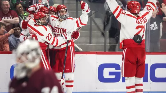 The men's ice hockey team celebrates a goal