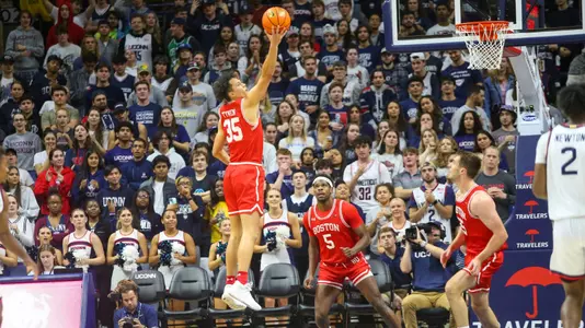 Fletcher Tynen leaps up for a ball at UConn with Walter Whyte and Nevin Zink looking on.