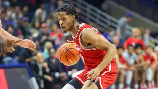 Ethan Brittain-Watts dribbles the ball with a UConn defender in front.