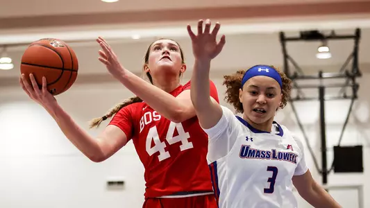 Photo of women's basketball freshman Sam Crispe going for a layup against UMass Lowell.