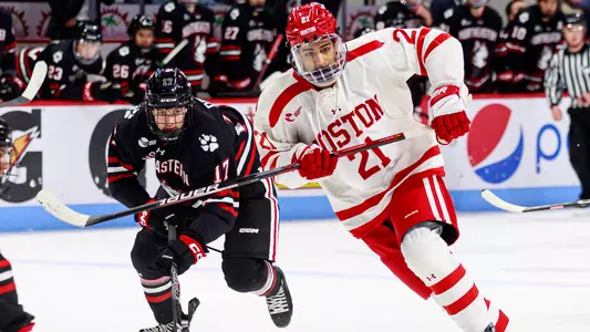 Devin Kaplan skating next to a Northeastern player