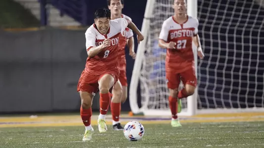 Daniel Kim sprints up the field with the soccer ball.