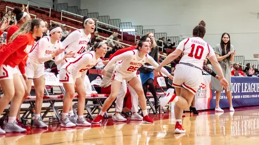 Photo of the women's basketball bench celebrating an Alex Giannaros basket.
