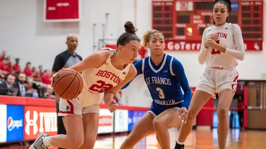 Photo of women's basketball senior Maggie Pina dribbling on the baseline against St. Francis Brooklyn.