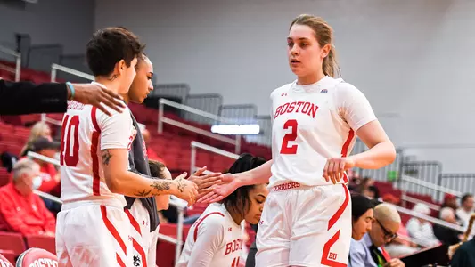 Photo of women's basketball freshman Ana Semenova high-fiving a teammate on the bench.