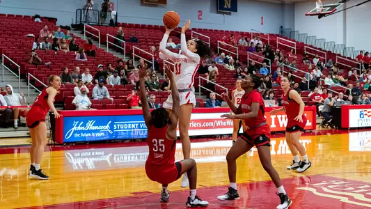 Photo of women's basketball junior Caitlin Weimar going for a layup against Northeastern.