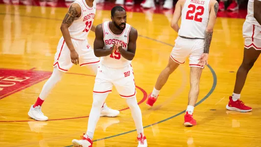 Jonas Harper claps his hands after hitting a basket and gets into defensive position.