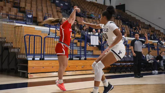 Photo of women's basketball sophomore Alex Giannaros shooting a three-pointer at Yale.