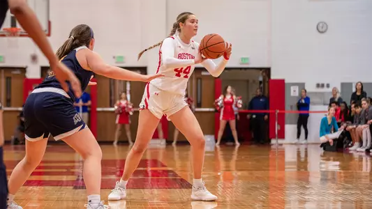 Photo of women's basketball freshman Sam Crispe passing the ball at the top of the key.