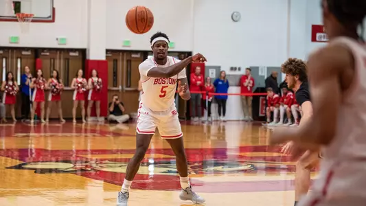 Walter Whyte passes the ball forward toward the camera as a player waits near the corner.