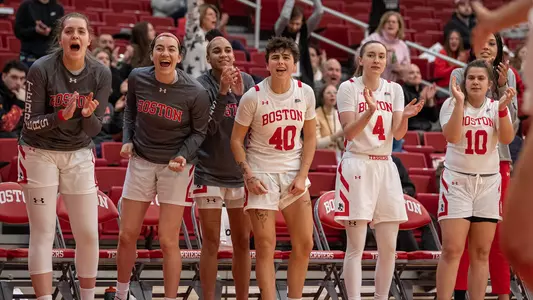 Photo of the women's basketball bench celebrating a play against Harvard.
