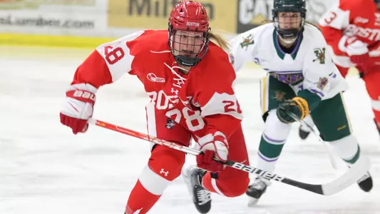 Catherine Foulem skating in front of a Vermont player