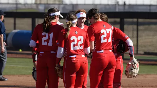 The BU softball infield huddles in the circle.