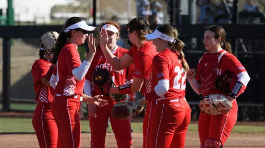 Softball team huddle high five one another in the circle
