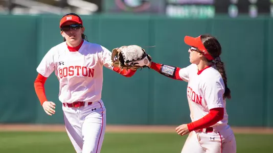 oston University softball Kayla Roncin and Aliyah Huerta-Leipner tap gloves walking off the field after the final out of an inning