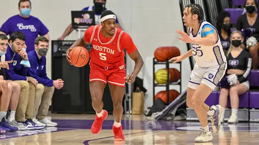 Walter Whyte dribbles the ball up the left side of the court with a defender on his left.