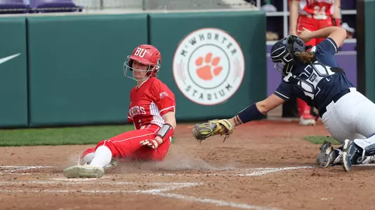 A Terrier slides into home plate with catcher trying to apply the tag with out-stretched arm
