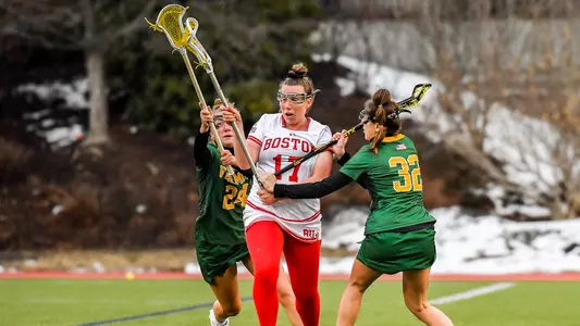 Maggie Lohrer split dodges two Vermont defenders.