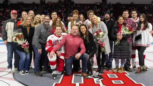 The men's ice hockey seniors pose with their families during a Senior Night ceremony