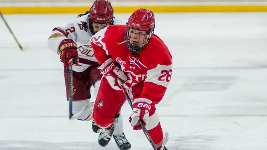 Catherine Foulem skating in front of a BC player