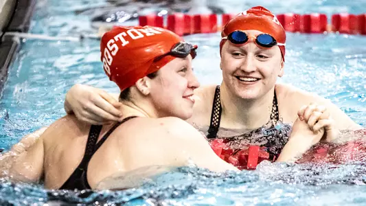 Two Terrier swimmers celebrate at the end of a race