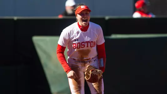 Caitlin Coker celebrates after an out with a yellow near third base.