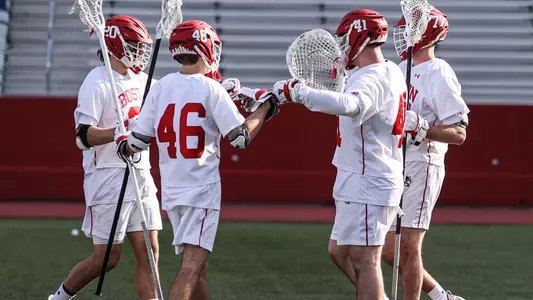 Will Carson, Dane DeGoler, Matt Garber and Patrick Morrison congratulate each other after a men's lacrosse win