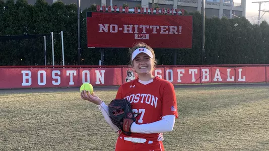 Lizzy Avery stands in front of the videoboard holding her softball and glove after pitching a no-hitter