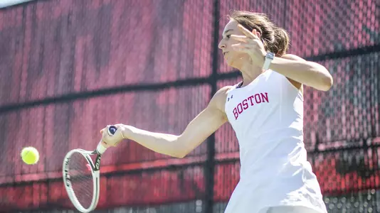 Erica Di Battista makes contact with a tennis ball on a forehand swing with her racquet.
