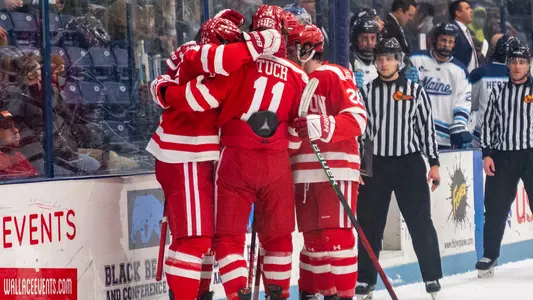 The men's ice hockey team celebrates a goal at Maine