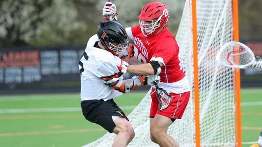 Will Carson checking a Princeton lacrosse player