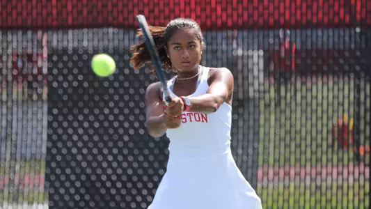 Sydney Sharma powers the tennis ball back from the baseline on a double backhand.