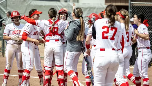 The BU softball team celebrates and hugs with Nicole Amodio following a walk-off victory