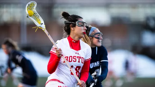 Lauren Kaye cradles the ball while dodging a UNH defender.