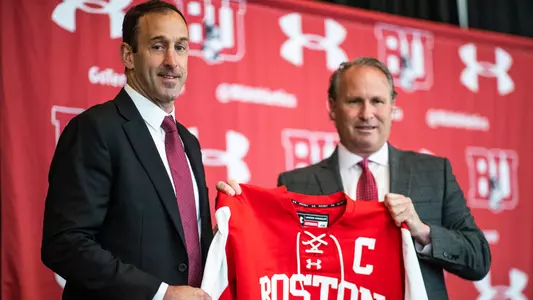 Jay Pandolfo holding a jersey with director of athletics Drew Marrochello