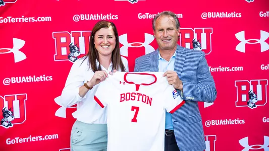 Women's Soccer Head Coach Casey Brown and Director of Athletics Drew Marrochello pose with Brown's soccer jersey at the 2022 Women's Soccer Kickoff Event.