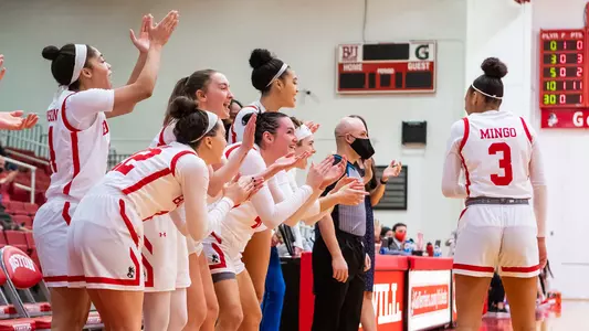 Photo of the women's basketball bench celebrating a basket.
